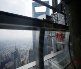 Jin Mao employee walks 340 meters above the ground around the newly opened Jin Mao tower skywalk in Shanghai. (Photo: Reuters)
