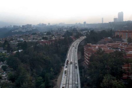Vista sulla linea ferroviaria interurbana México–Toluca in costruzione, nella zona ovest di Città del Messico. In primo piano si osservano complessi residenziali con serbatoi d’acqua integrati nei volumi architettonici